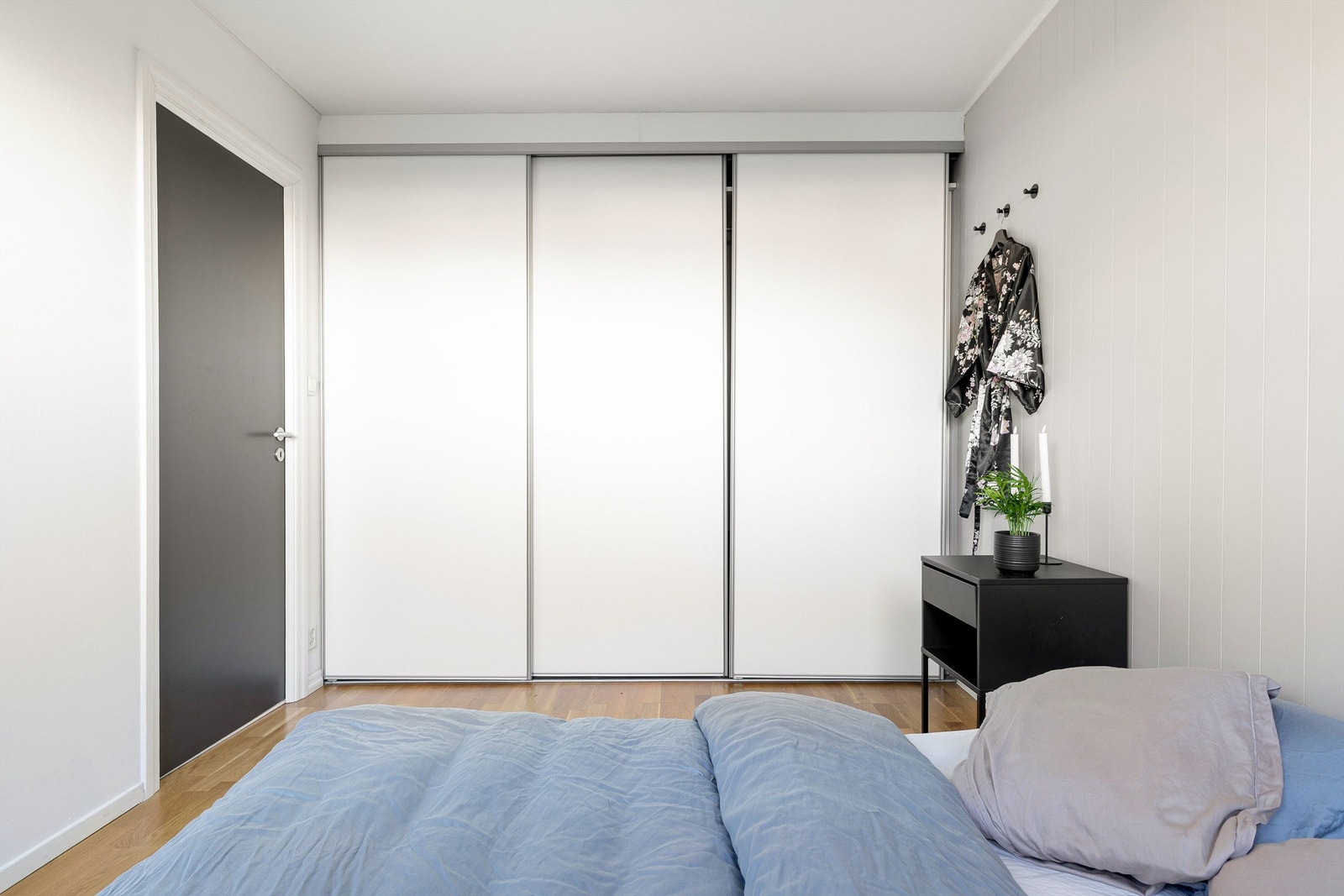 Veggplassen er godt utnyttet med stor skyvedørsgarderobe Galleribilde