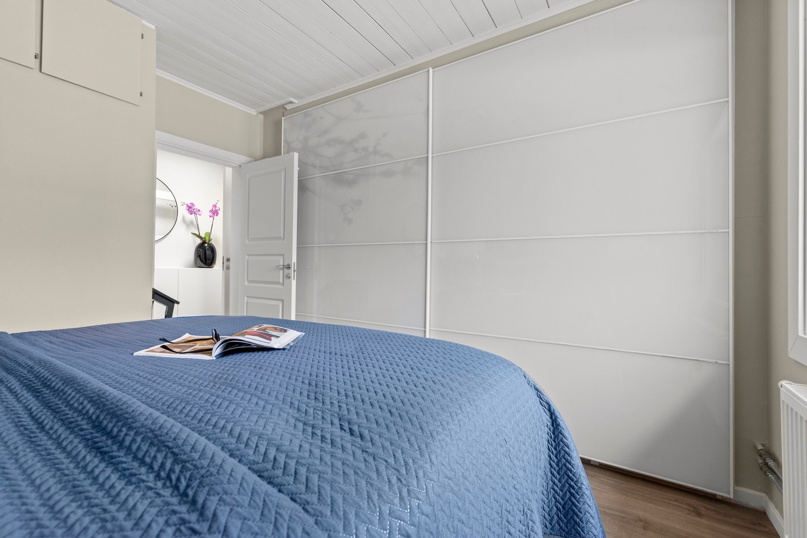 Her er det innredet med garderobeskap som gir praktisk oppbevaringsplass for klær og sengetøy, og bidrar til et ryddig og organisert rom. Galleribilde