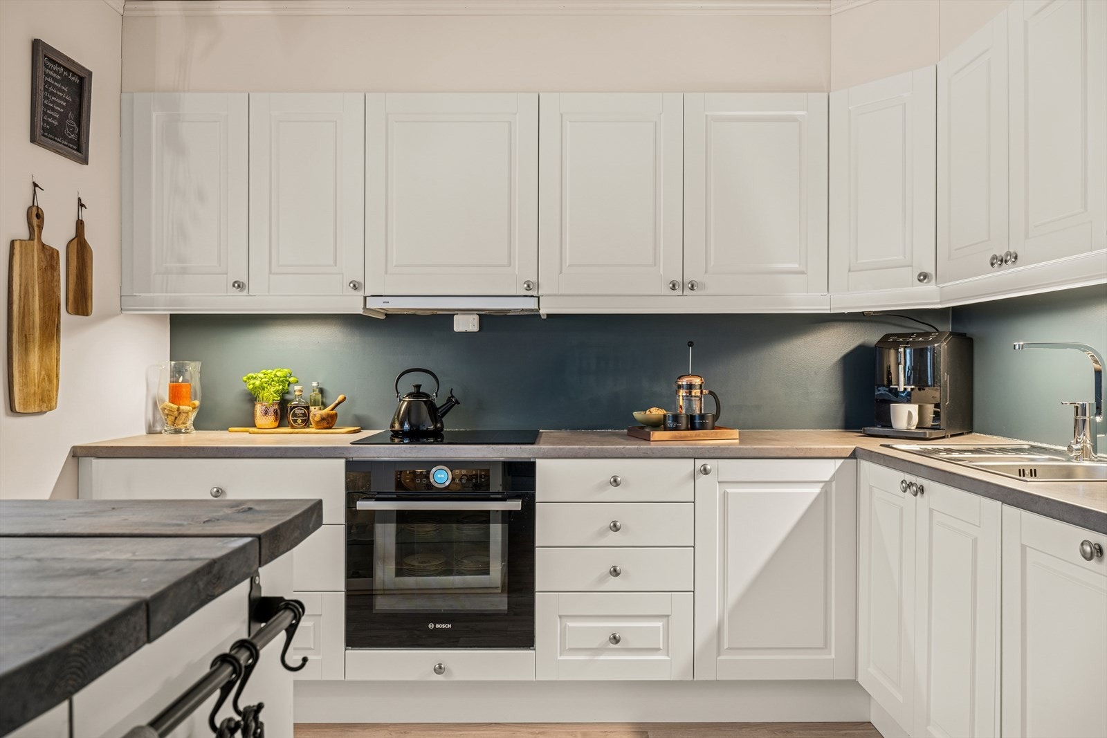 Kjøkkenets innredning har folierte skrog og fronter, samt en benkeplate med høytrykkslaminert overflate og nedfelt kum av stål. Galleribilde