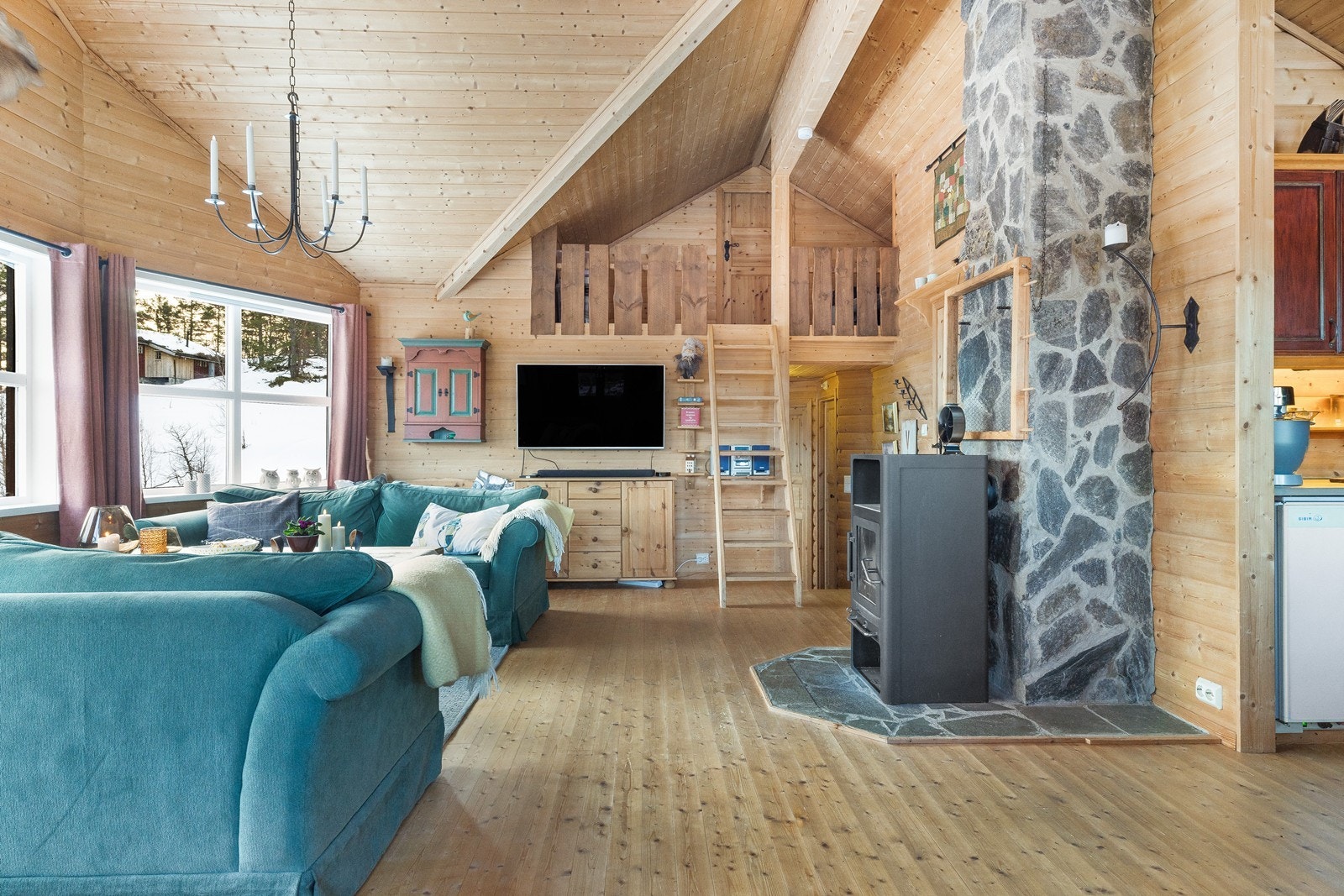 Tregulv og panelvegger gir en varm og naturlig følelse i stuen. Galleribilde