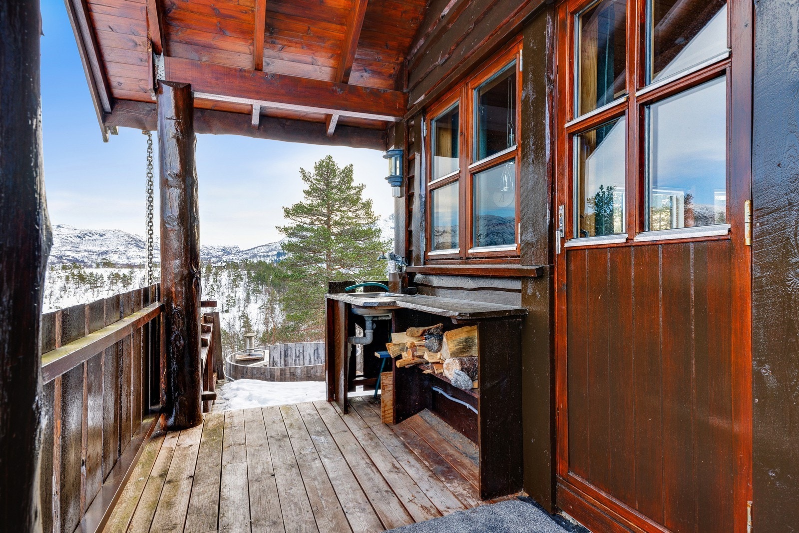 Terrassen har en praktisk utendørs vaskekum og vedoppbevaring. Galleribilde