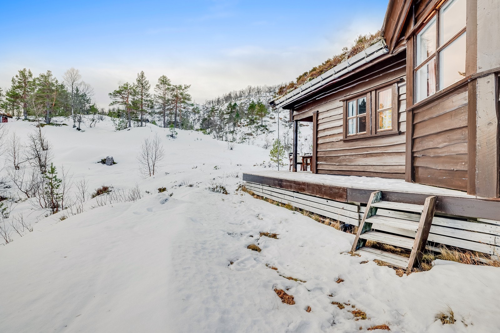 Trepanelene på ytterveggene gir hytten et rustikt utseende, godt integrert i naturen. Galleribilde