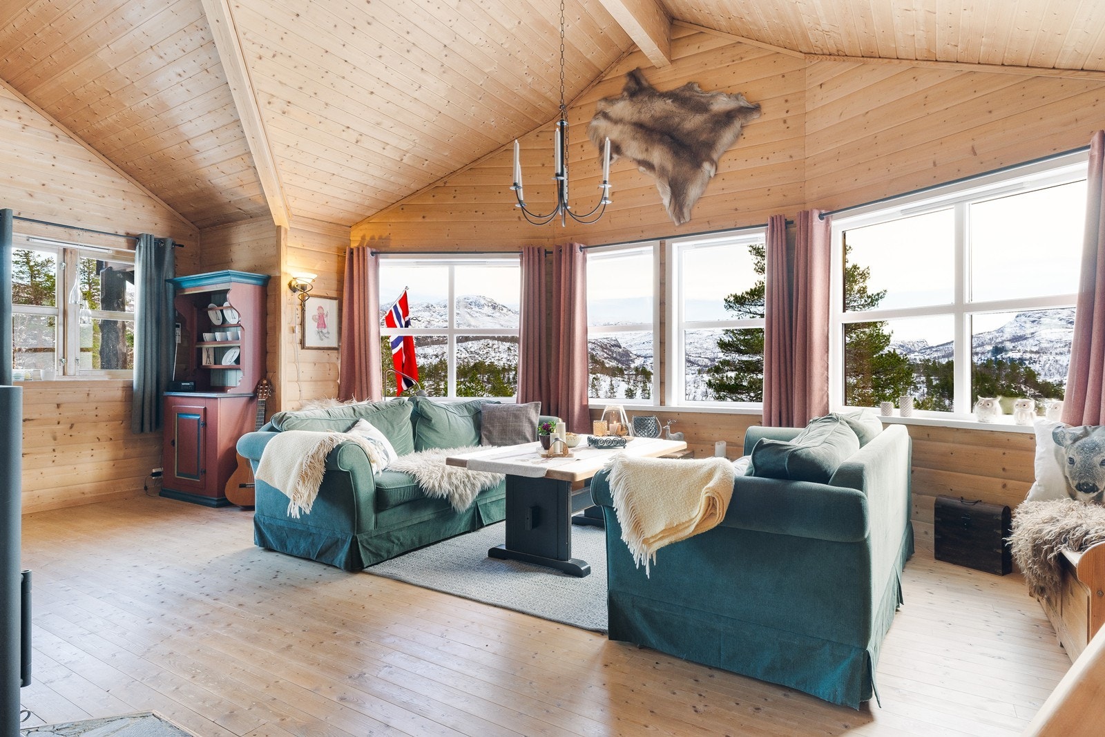 Store vindusflater gir utsikt mot fjellandskap. Galleribilde