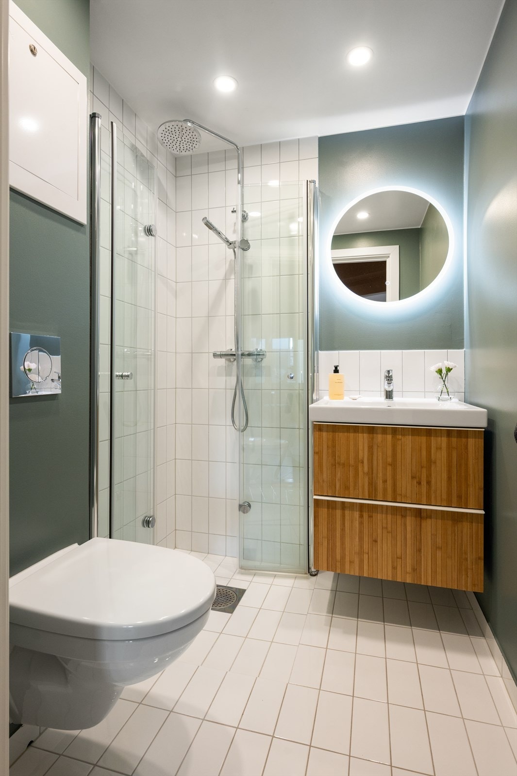 Badet har flislagt gulv med behagelig varme. Veggene er kledd med både fliser og malte overflater. Galleribilde