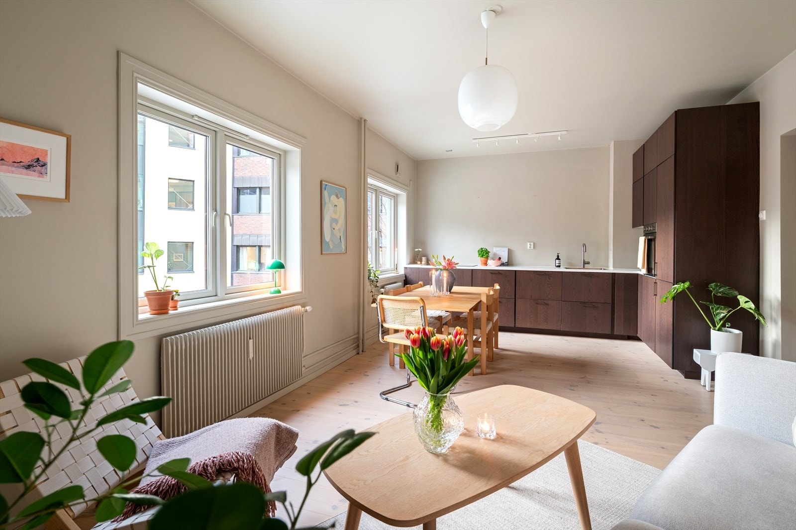 Den åpne kjøkken- og stueløsningen skaper en sosial og luftig atmosfære, der lys og rom flyter sømløst mellom sonene - perfekt for både hverdagsliv og hyggelige sammenkomster. Galleribilde