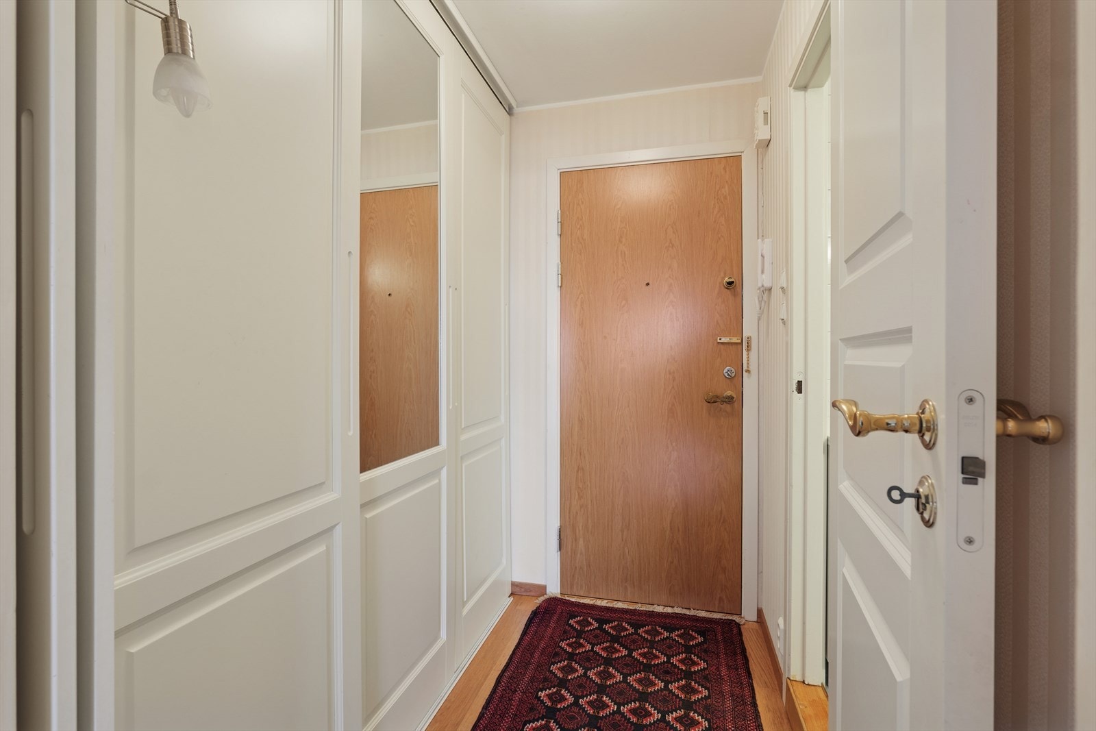 Arealet er maksimalt utnyttet, så i gangen er det vegg til vegg skyvedørsgarderobe Galleribilde