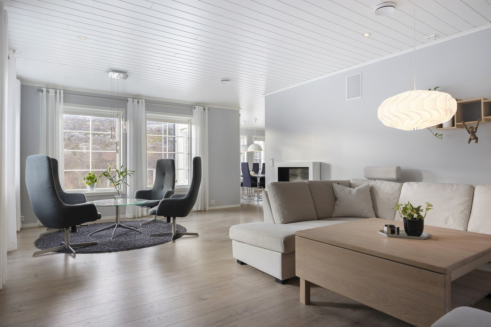 Stuen er lys og innbydende, med store vindusflater som slipper inn naturlig dagslys. Planløsningen mellom stue og kjøkken er åpen og sosial, samtidig som det er plass til flere sittegrupper. Galleribilde