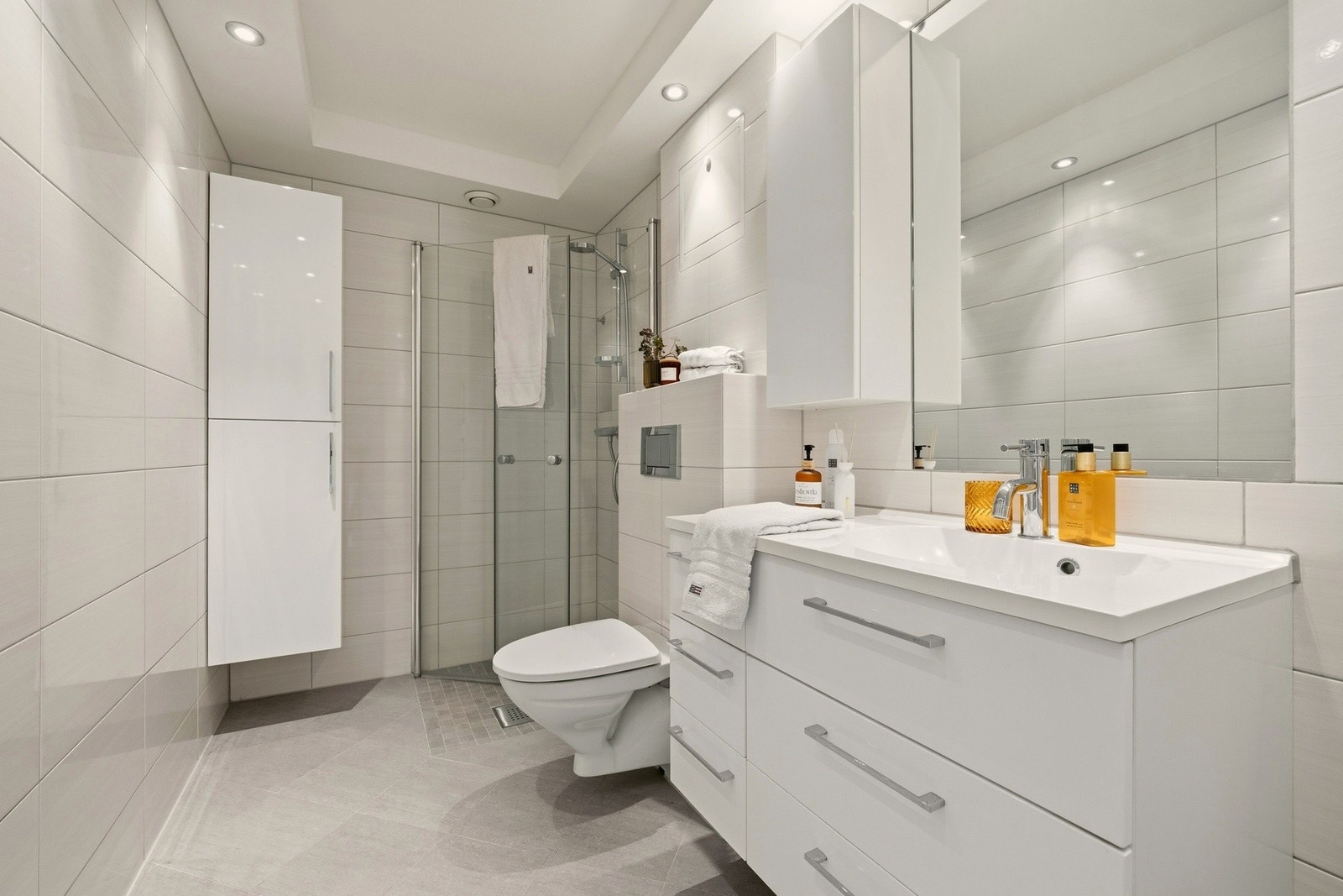 Badet har dusjhjørne, vegghengt toalett og opplegg for vaskemaskin Galleribilde