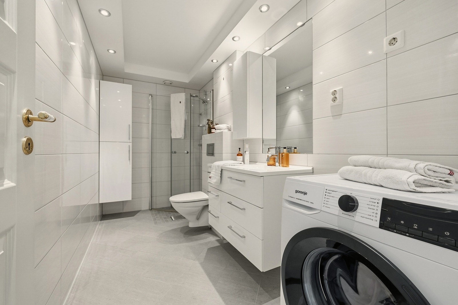 Leiligheten har et stort bad med flislagte vegger og gulv med varmekabler Galleribilde