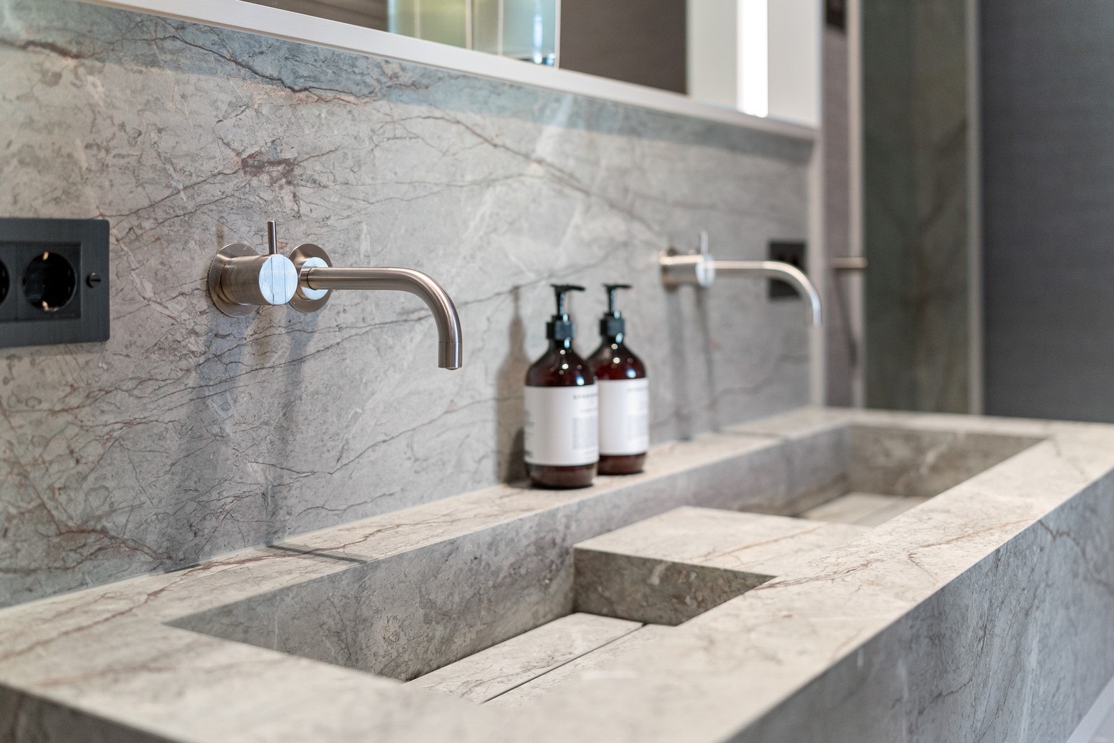 Masterbadet inneholder vegghengt toalett, dobbel servant med integrerte armaturer og separat dusjsone med steamdusjløsning. Galleribilde