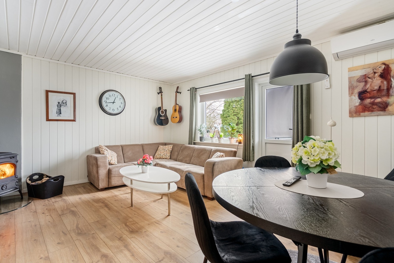 En lys og koselig stue med rikelig naturlig lys takket være store vindusflater som skaper en luftig og behagelig atmosfære Galleribilde