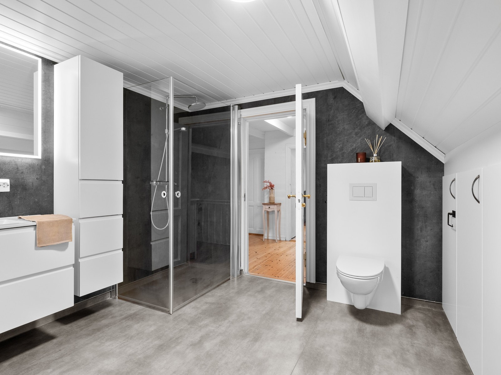 Badet ble oppgradert med nye overflater, varmekabler og innredning i 2021. Badet har belegg på gulv og våtromsplater på vegg. Rommet er innredet med servantskap, to høyskap og speil med belysning. Videre er badet utstyrt med toalett og innfellbare dusjdør Galleribilde