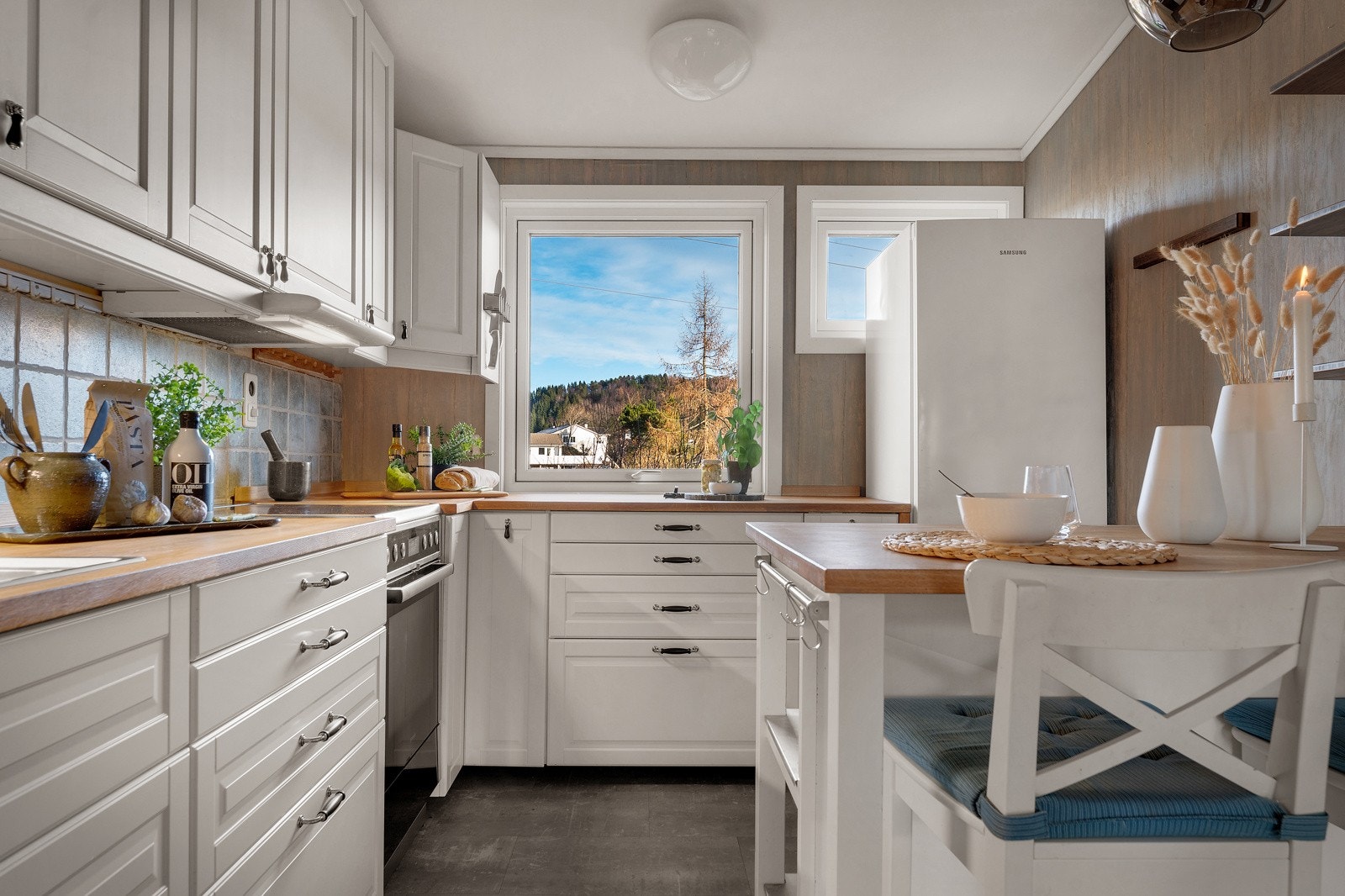 - Kjøkkeninnredningen har profilerte fronter, heltre benkeplate og fliser over benk - Galleribilde