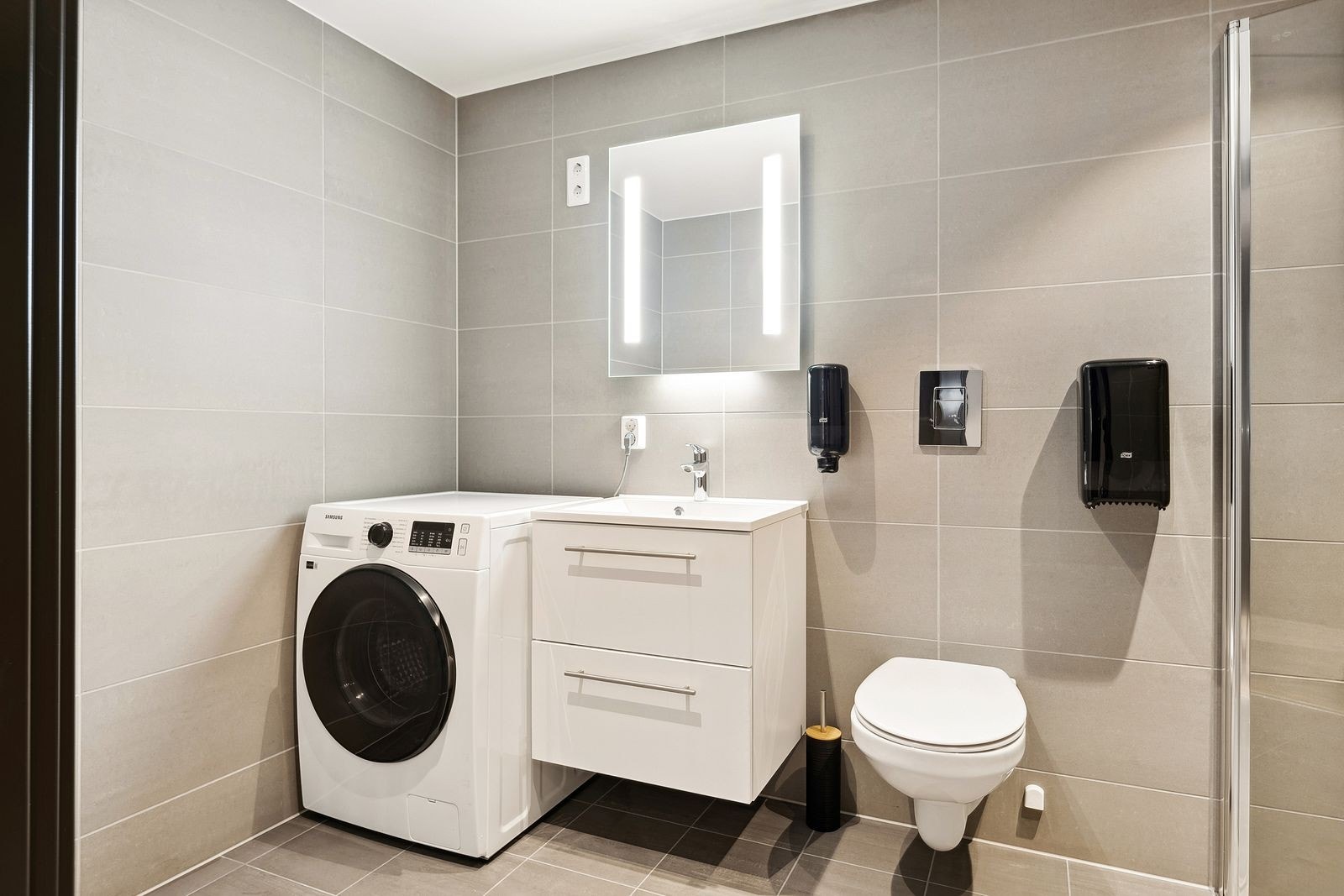 Helservant på hvit skuffeinnredning, speil m/belysning og opplegg til vaskemaskin. Kombimaskin vask/tørk medfølger salget. Galleribilde