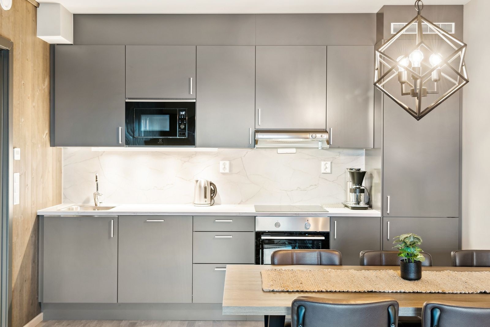 Klassisk og tidløs kjøkkeninnredning fra Norema med integrerte hvitevarer som kombiskap kjøl/frys, stekeovn, platetopp og microovn. Laminat benkeplate og praktisk kitchenboard i marmorimitasjon mellom benk og overskap. Galleribilde