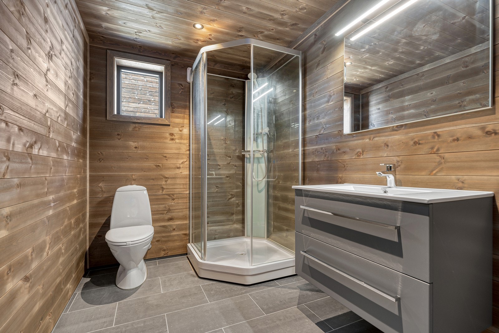 Flott bad med flislagt gulv m/oppkant (varmekabler på gulv) og liggende panel Galleribilde