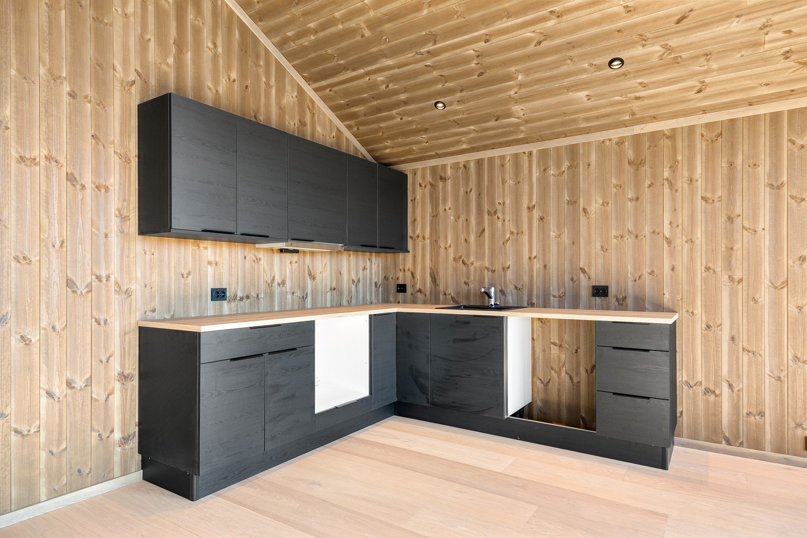 Kjøkkenet har en mørk og tidløs utførelse. Her er det godt med stikkontakter over kjøkkenbenken til alle kjøkken apparater Galleribilde