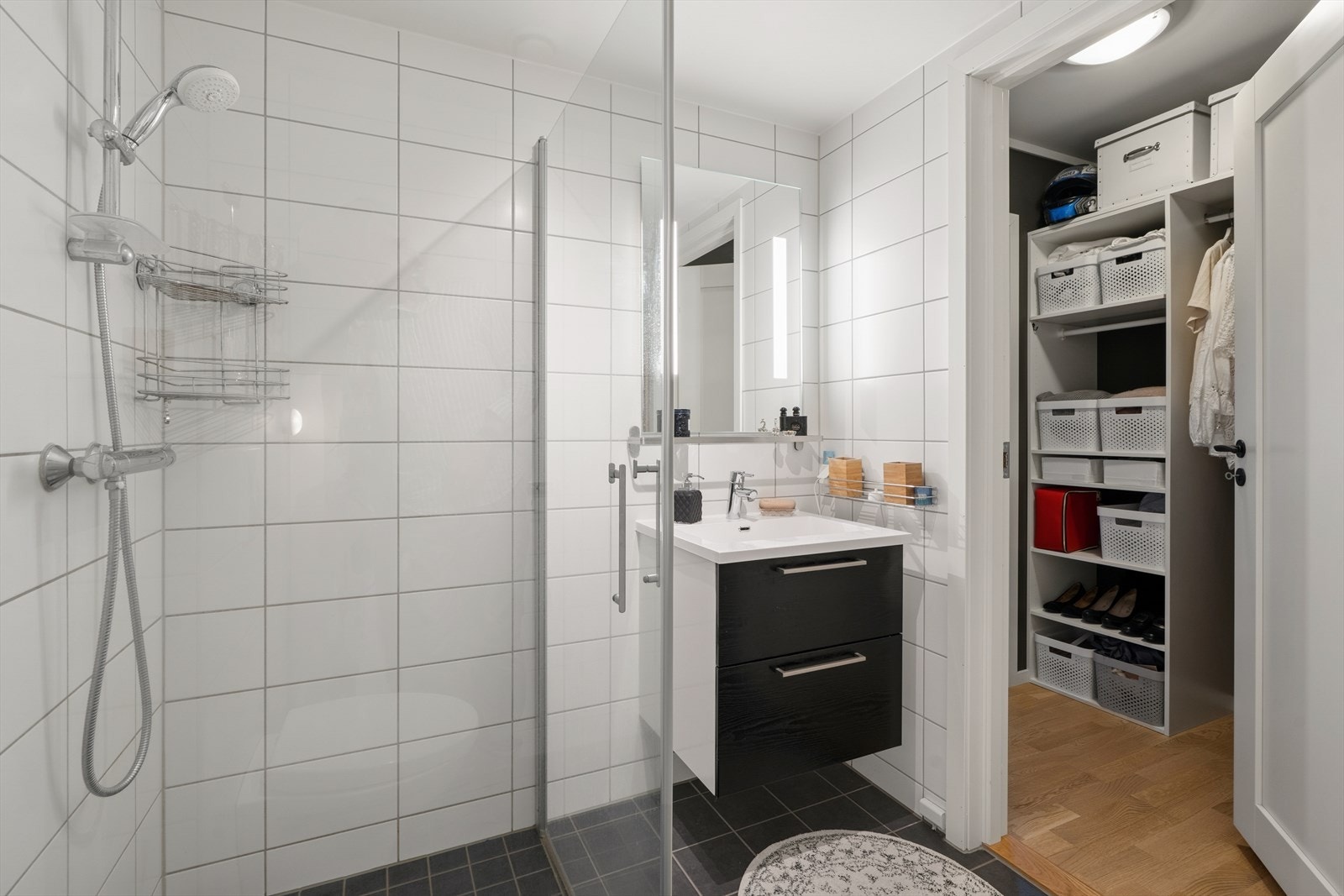 Hovedbadet er utstyrt med baderomsinnredning med servant og bl. batteri, speil med lys, dusjhjørne med glassdører og vegghengt toalett. Galleribilde