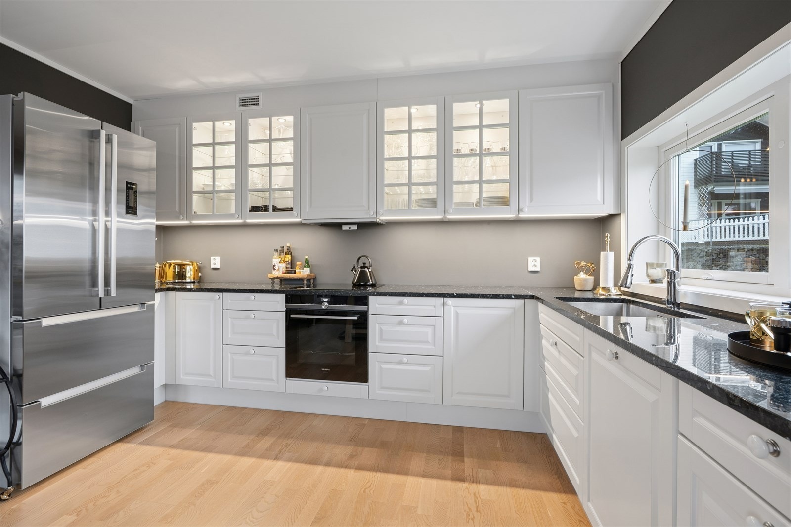 Kjøkken fra HTH med profilert kjøkkeninnredning, granitt benkeplate, utslagsvask med blandebatteri og kjøkkenventilator. Galleribilde