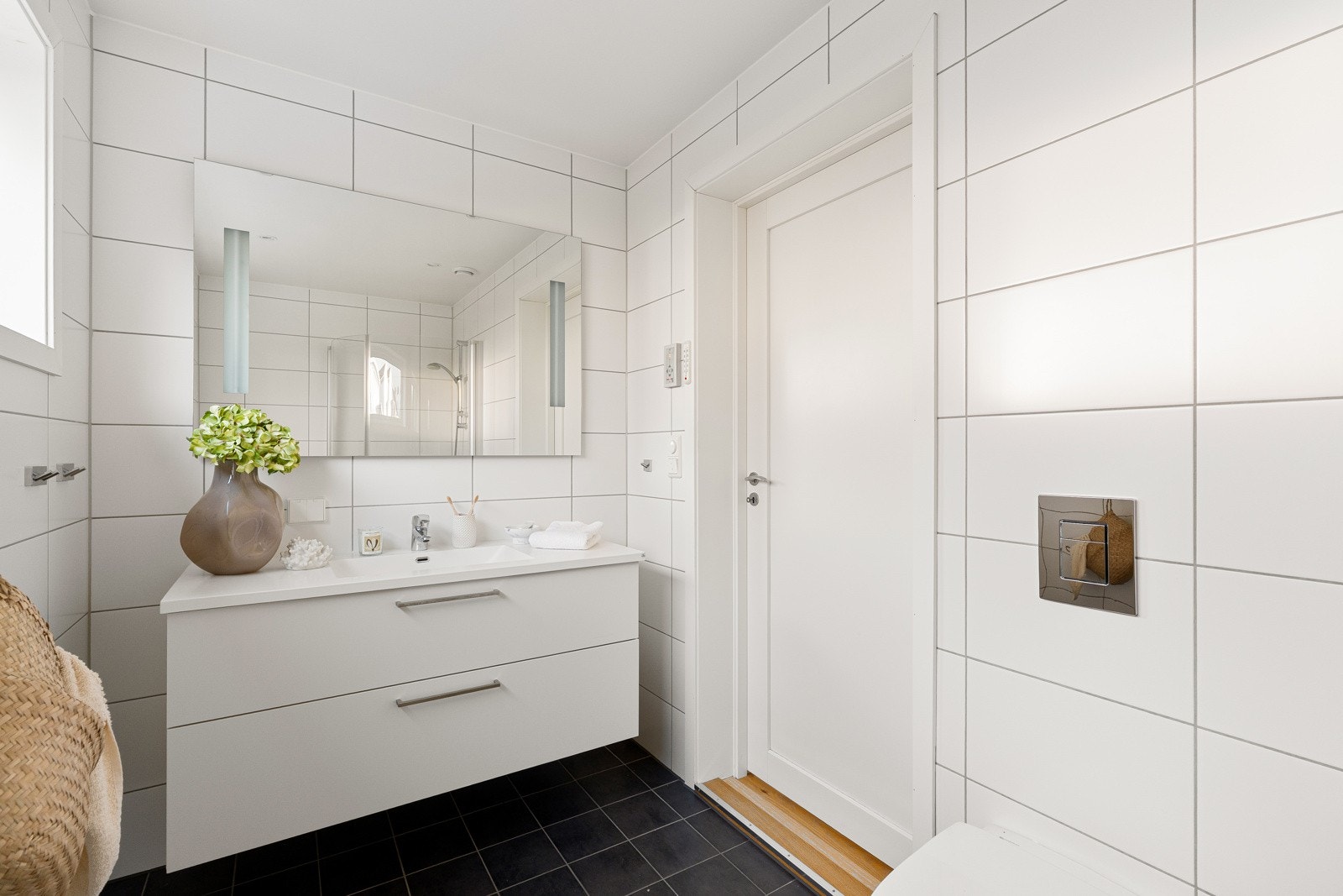 Badet oppe er stilrent med mørkegrå gulvfliser og lysegrå veggfliser. Galleribilde