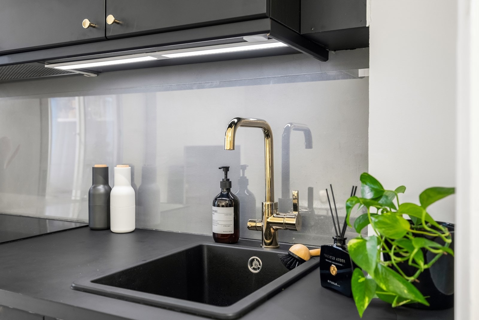 Elegant arbeidsområde med nedfelt vask, god benkedybde og glassplate på vegg som gir et rent og vedlikeholdsvennlig uttrykk. Galleribilde