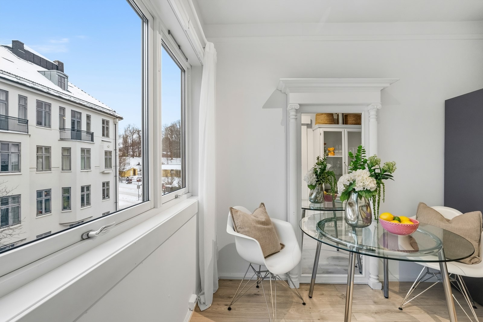 Spiseplass plassert ved vindu med hyggelig utsyn mot klassisk bygårdsbebyggelse. Galleribilde