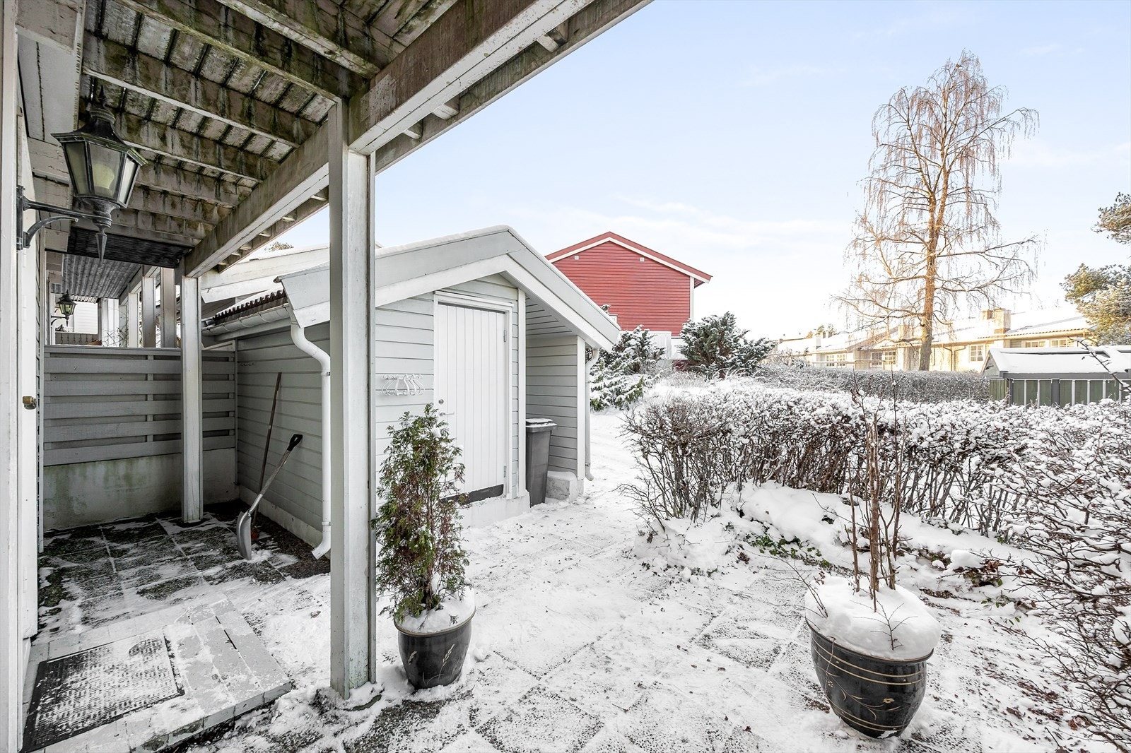 Ved inngangspartiet er det en overbygd uteplass og en praktisk utebod. Galleribilde