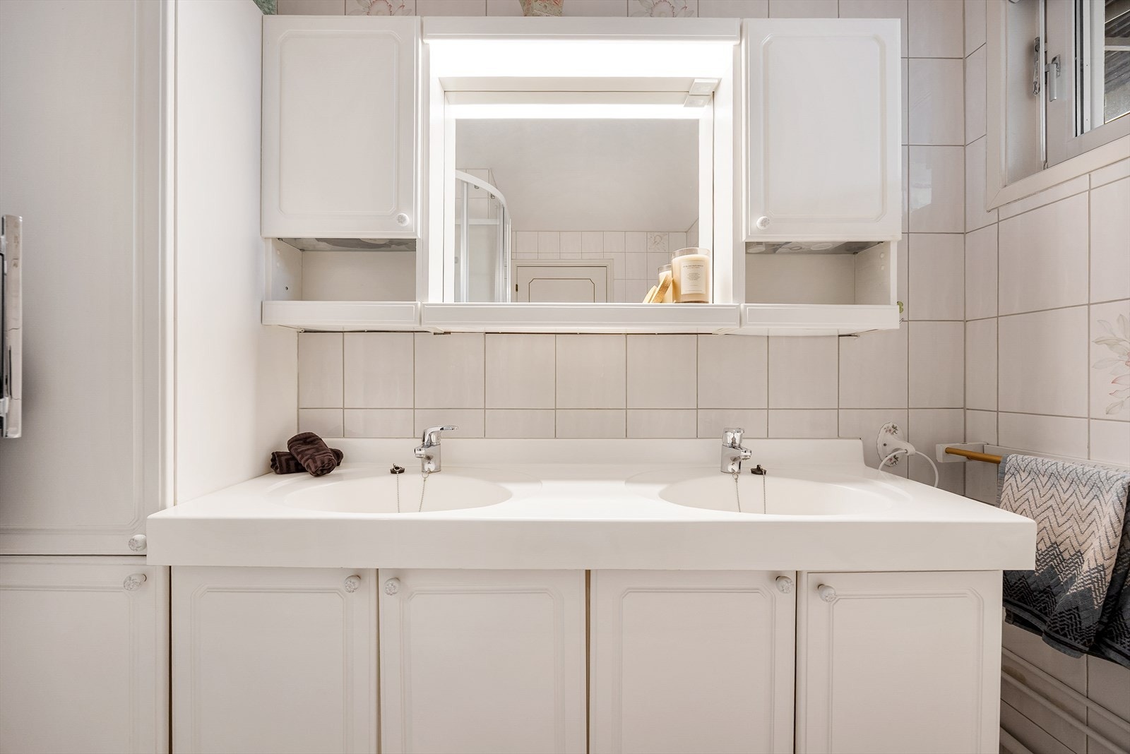 Baderomsinnredningen har doble servanter og godt med oppbevaringsplass. Galleribilde