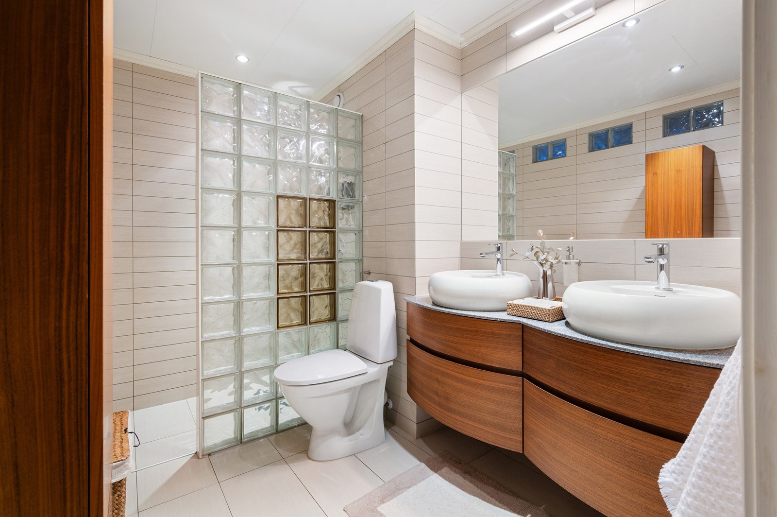 Badet fremstår lyst og moderne med flislagte overflater og elektrisk varme i gulvet. Galleribilde