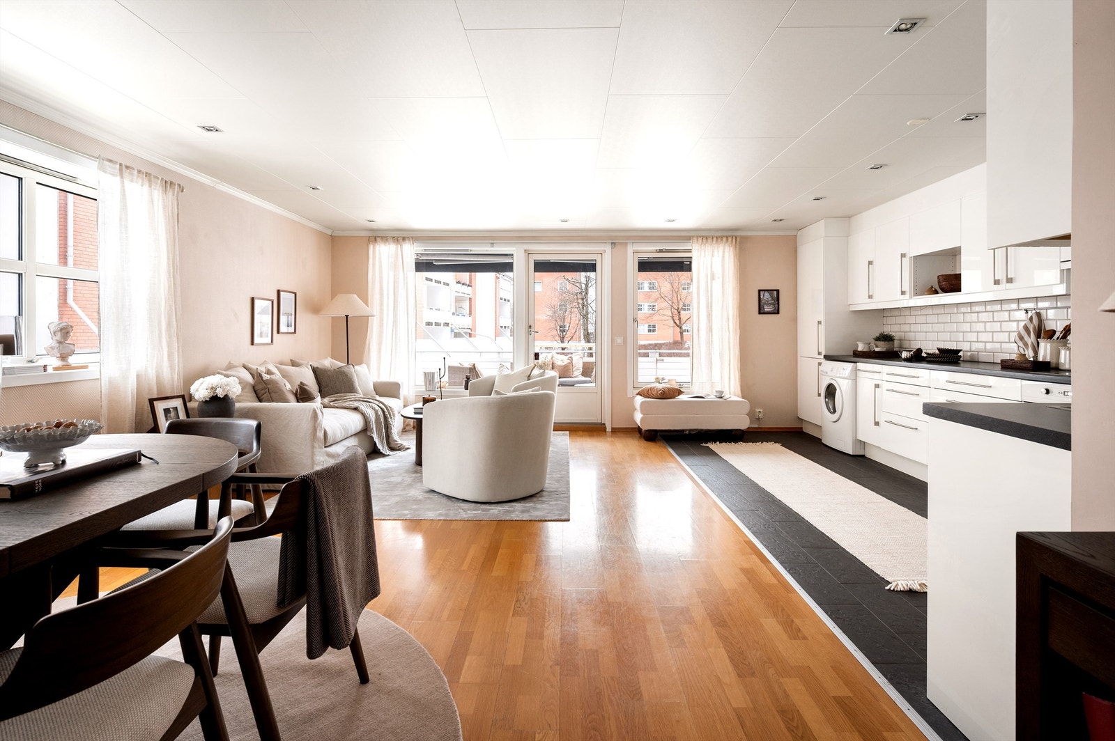 Den åpne stue-/kjøkkenløsningen gir god kommunikasjon mellom de ulike sonene og skaper et naturlig rom for sosiale sammenkomster. Galleribilde