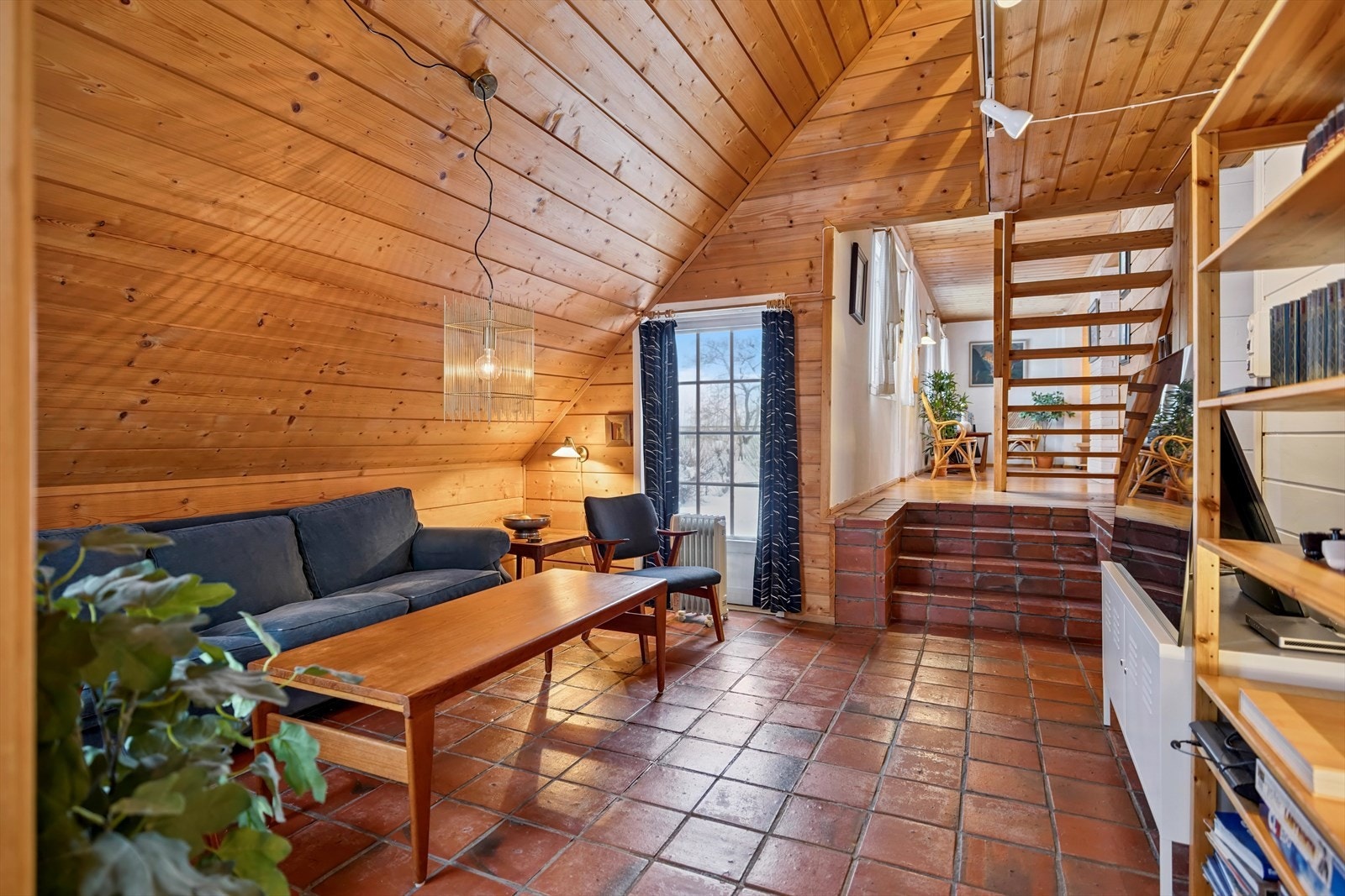 TV-stuen har en lun atmosfære med panelkledde vegger og tak. Galleribilde