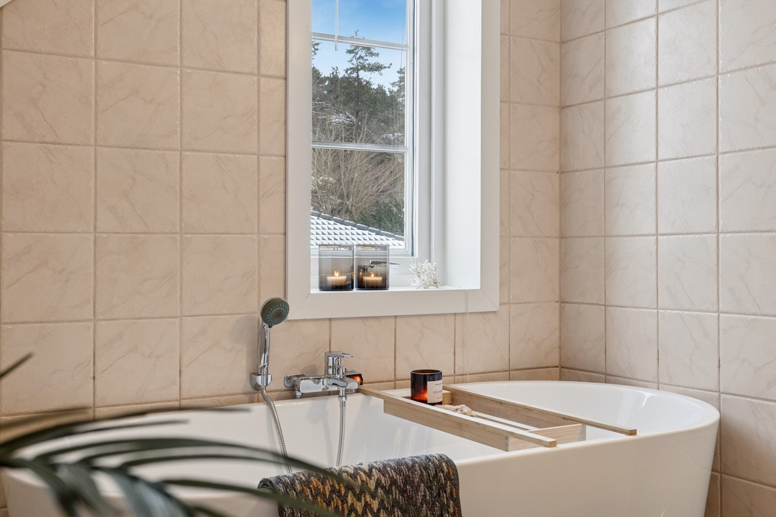 På badet er det badekar, vegghengt toalett, samt baderomsinnredning Galleribilde