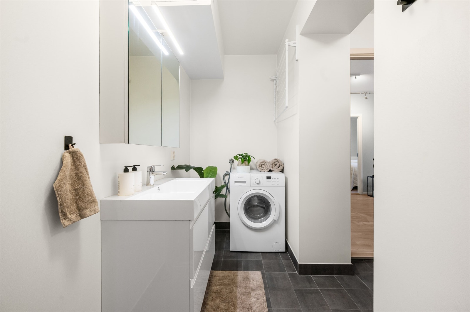 Moderne bad med elektrisk gulvvarme for økt komfort. Badet er innredet med vegghengte servantskuffer med servant og speilskap over servanten. Galleribilde