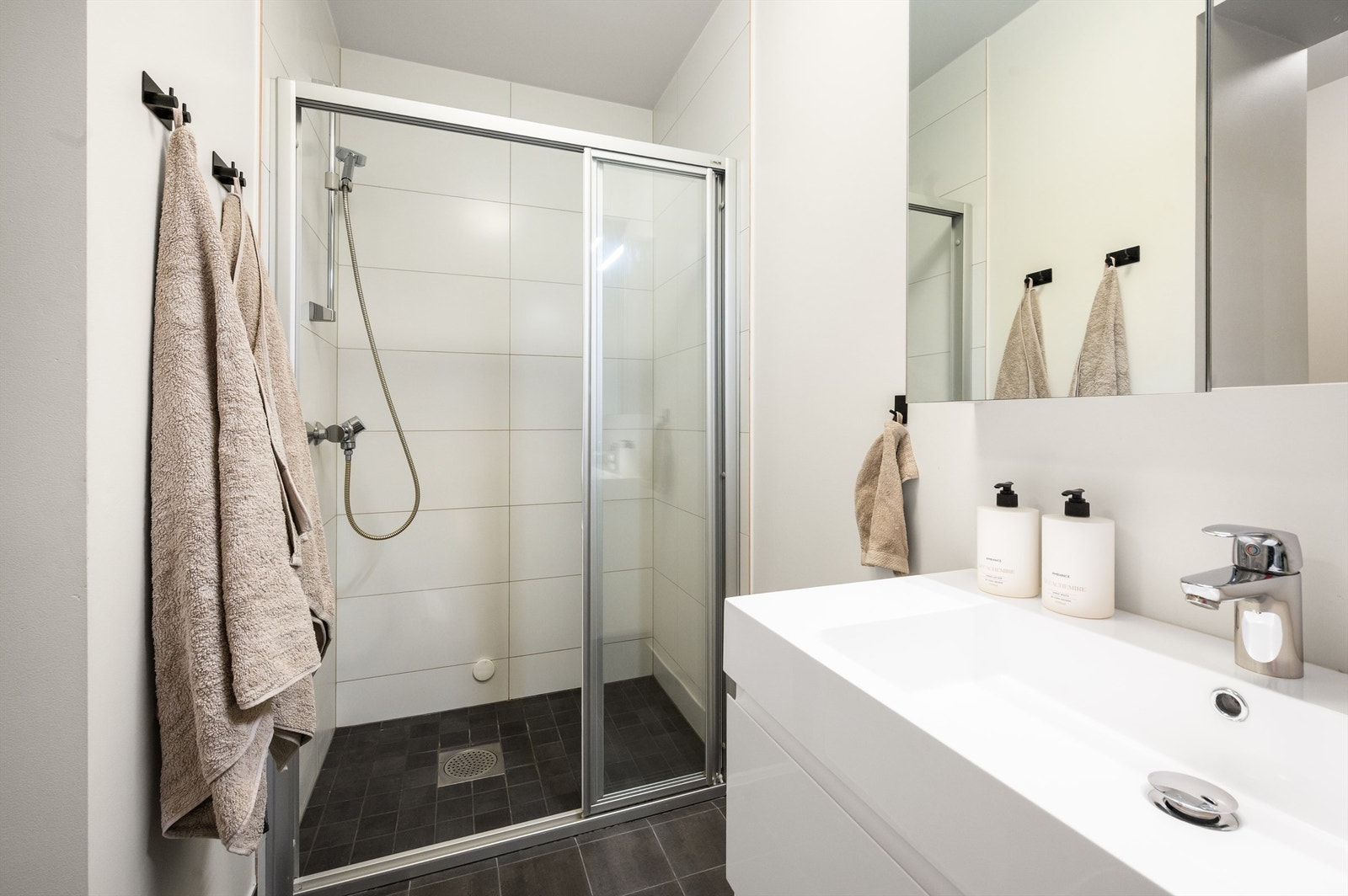 Dusjsonen er flislagt og har et plassbesparende dusjhjørne med skyvedører. Galleribilde