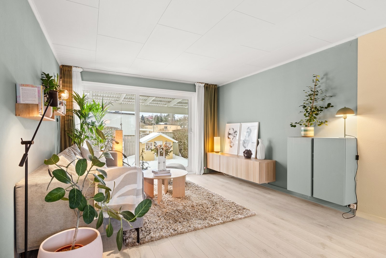 Store vindusflater gir rikelig med naturlig lysinnslipp. Stuen ble oppgradert med nye vinduer og terrassedør i 2025. Galleribilde