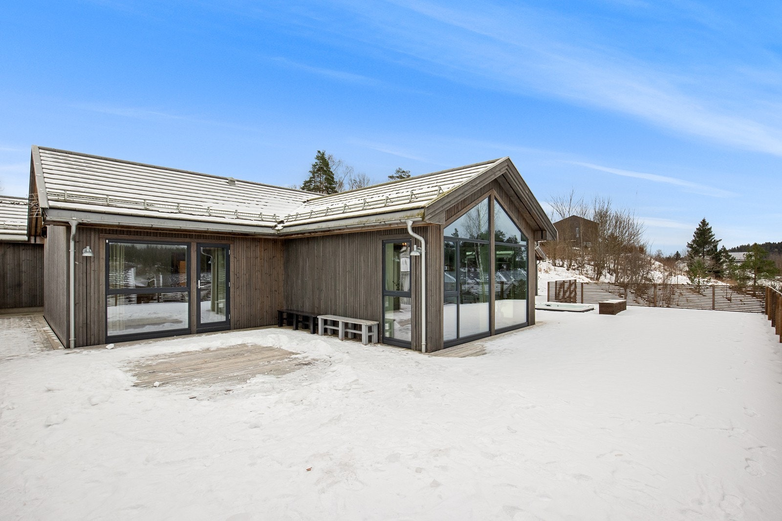 Gjennomgående bruk av store vinduer binder uteområdet sammen med boligen. Galleribilde