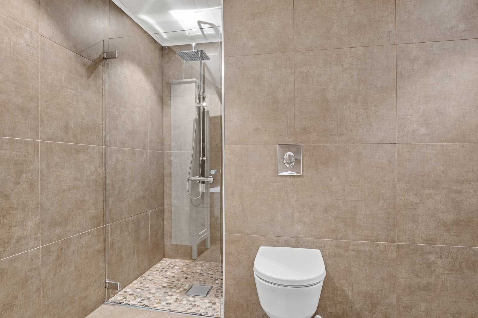 Badet har også en separat dusjnisje med regnfallsdusj og vegghengt toalett. Galleribilde