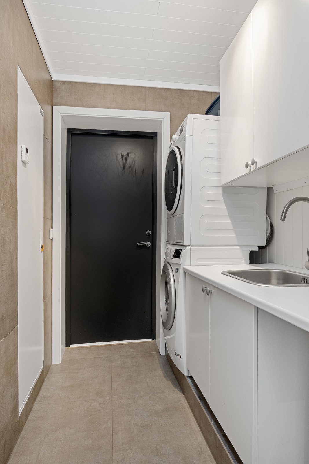 Praktisk vaskerom med opplegg for vaskemaskin og tørketrommel, samt egen utgang. Galleribilde