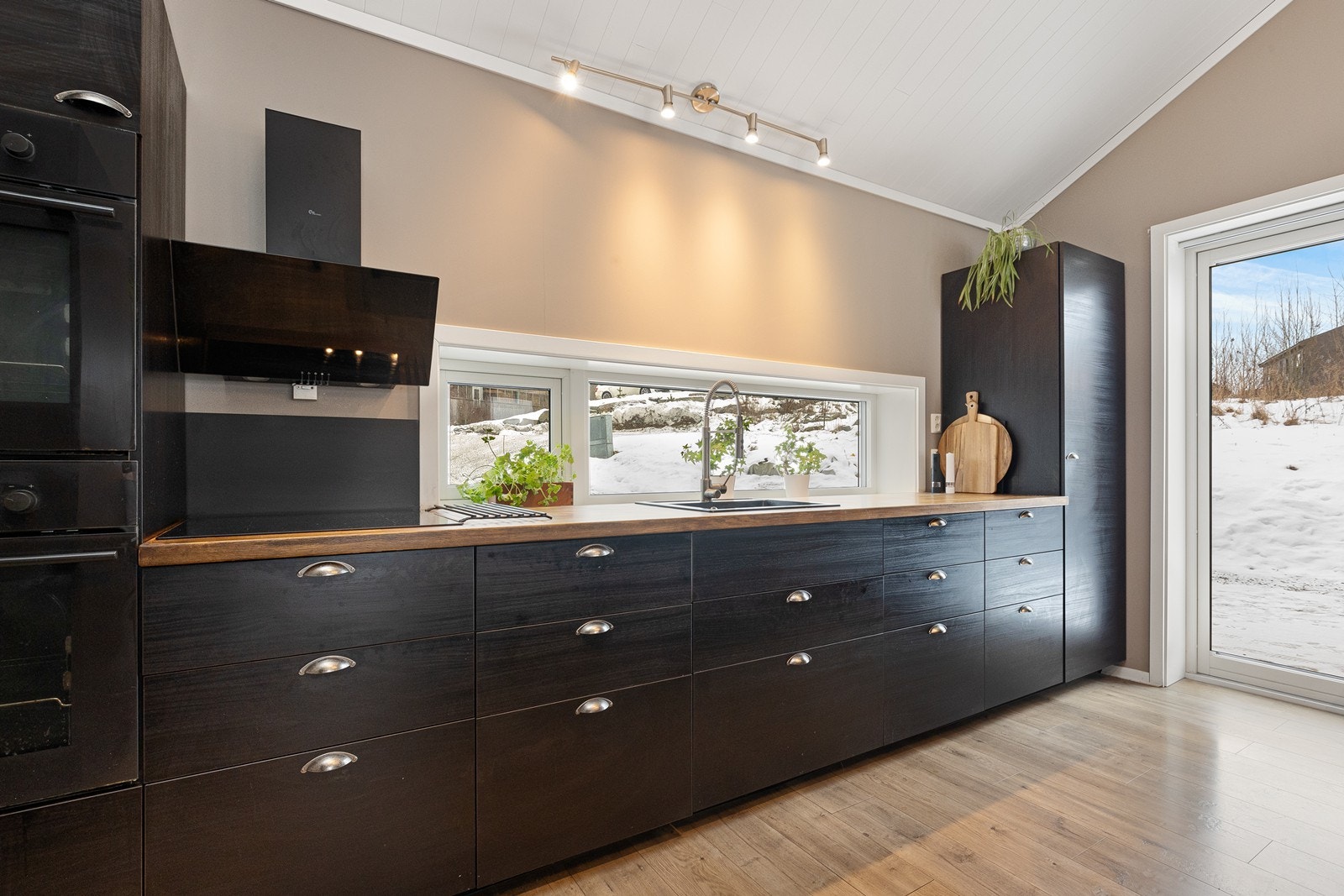 Lange benkeplater gir gode arbeidsforhold, og kjøkkenet har integrerte hvitevarer. Galleribilde