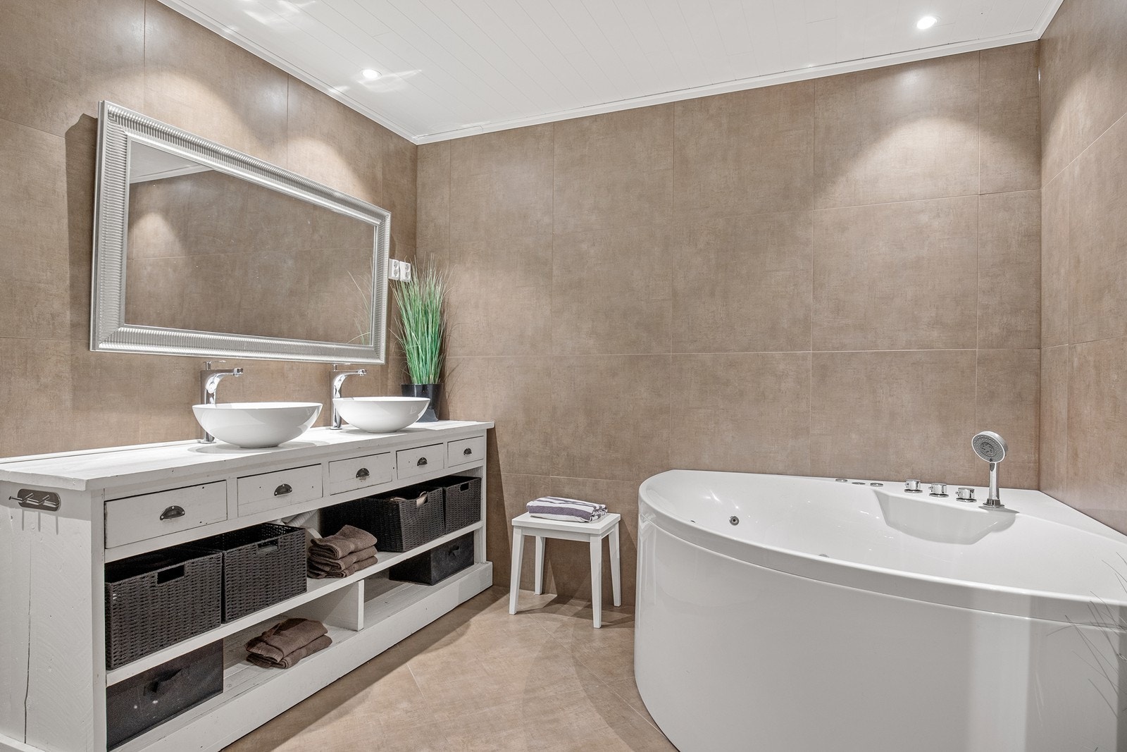 Stort og delikat bad med dobbel servant og et romslig hjørneboblekar. Galleribilde