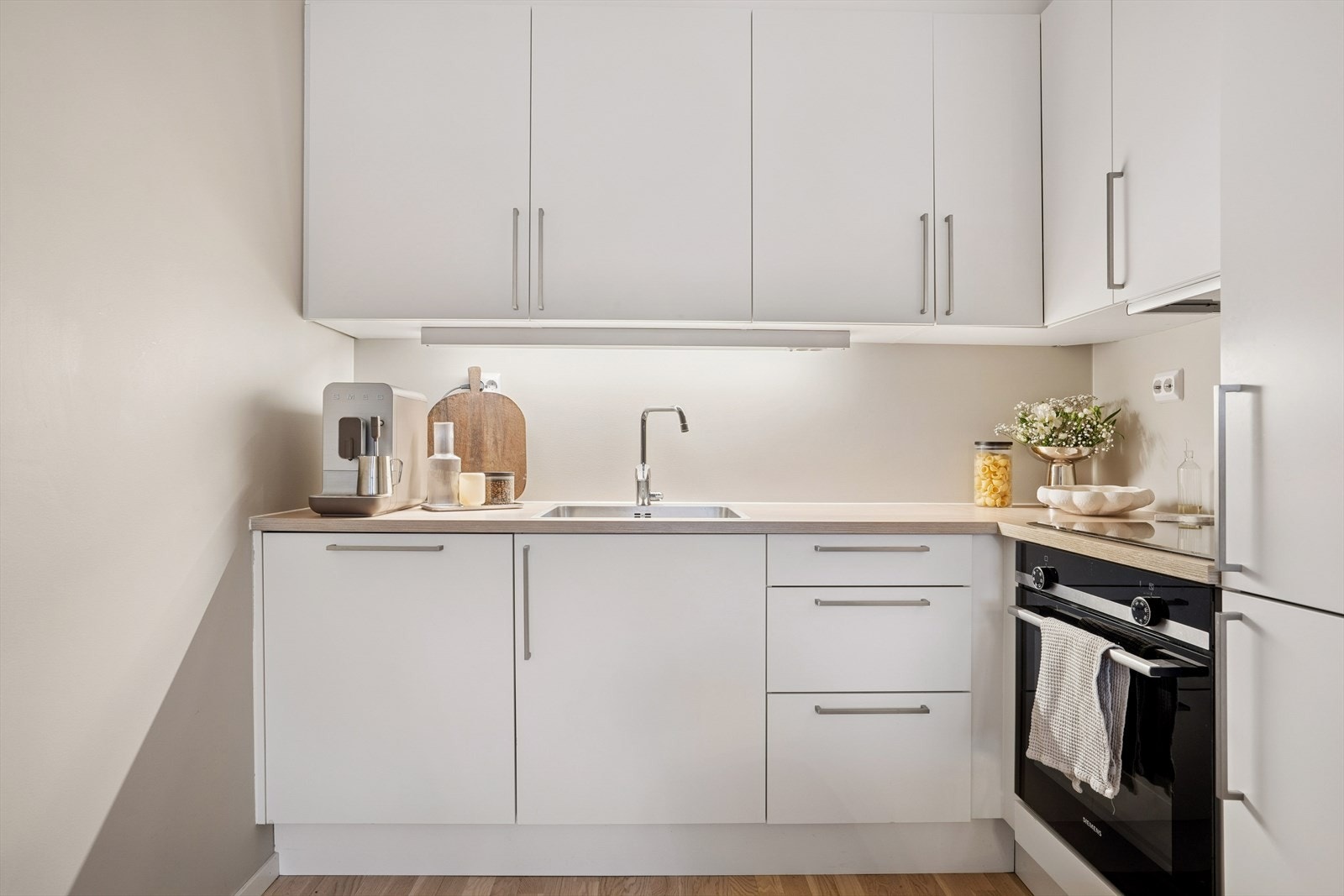 Den takoppforede innredningen fra HTH har hvite fronter og laminat benkeplate. Galleribilde