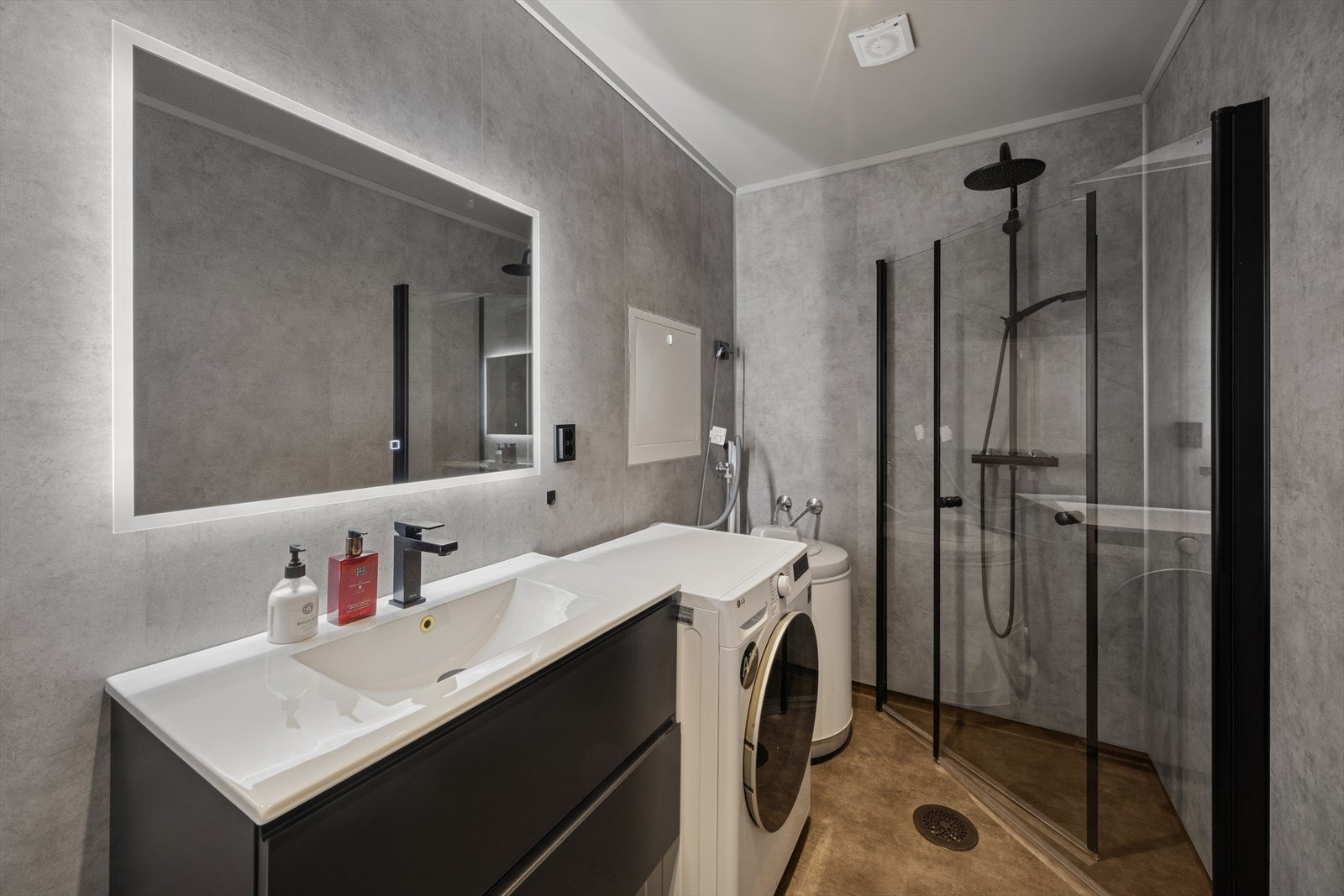 Innredningen inneholder servant med underskuffer, speil, dusjhjørne og opplegg for vaskemaskin. Galleribilde