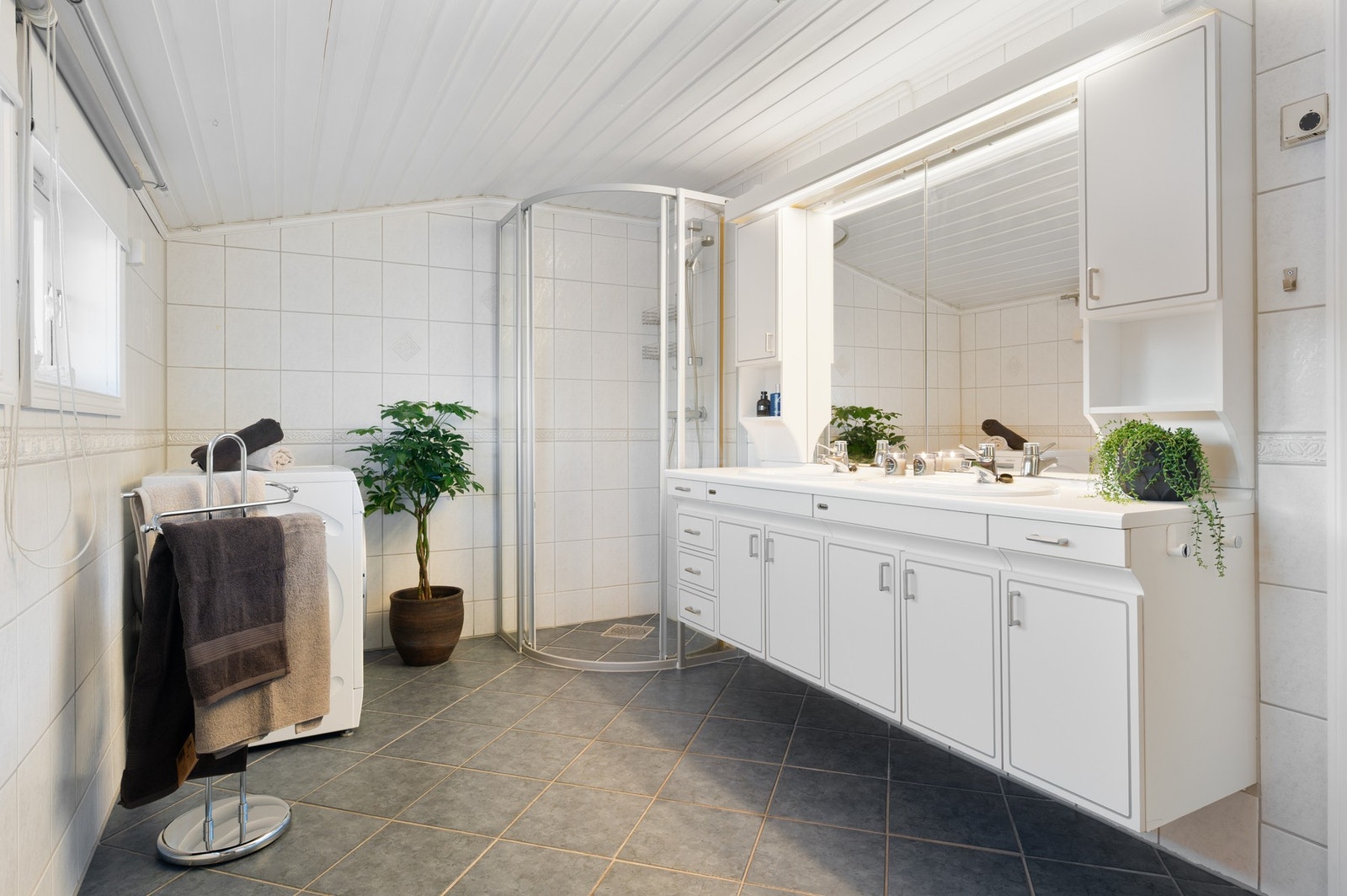 Lyst og romslig flislagt bad på 8,9m² med alt man trenger. Galleribilde