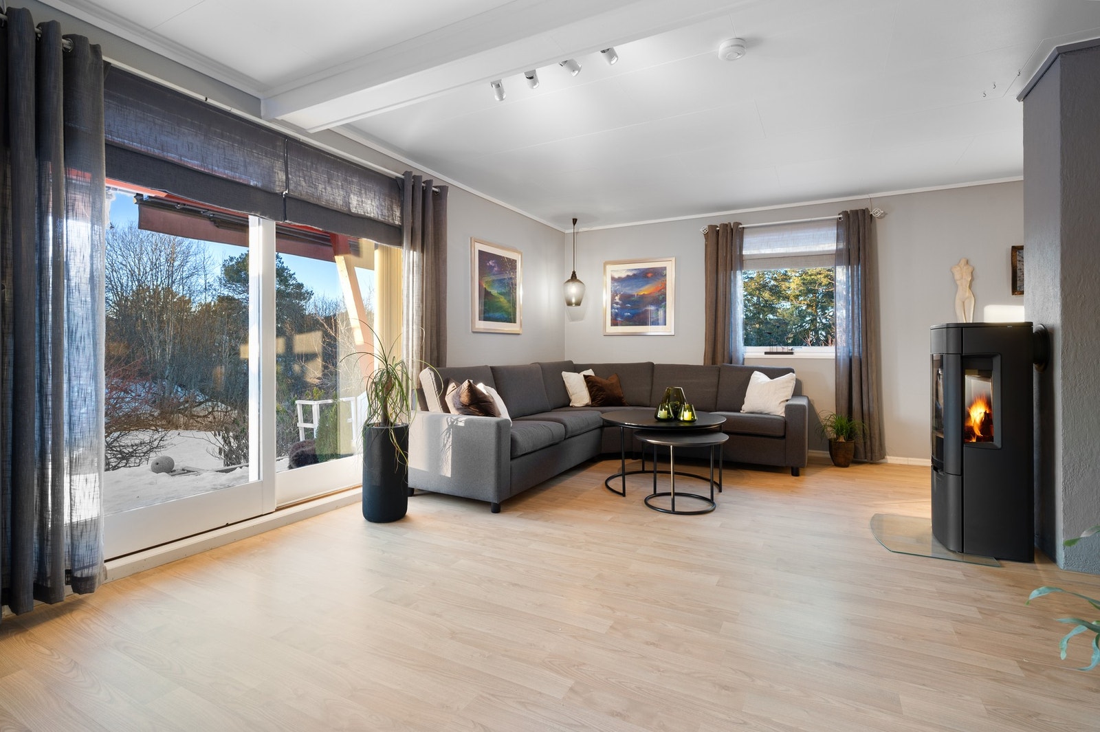 Koselig del av stuen med peis. Vedfyring er et hyggelig alternativ som hjelper å holde energikostnadene lave. Galleribilde