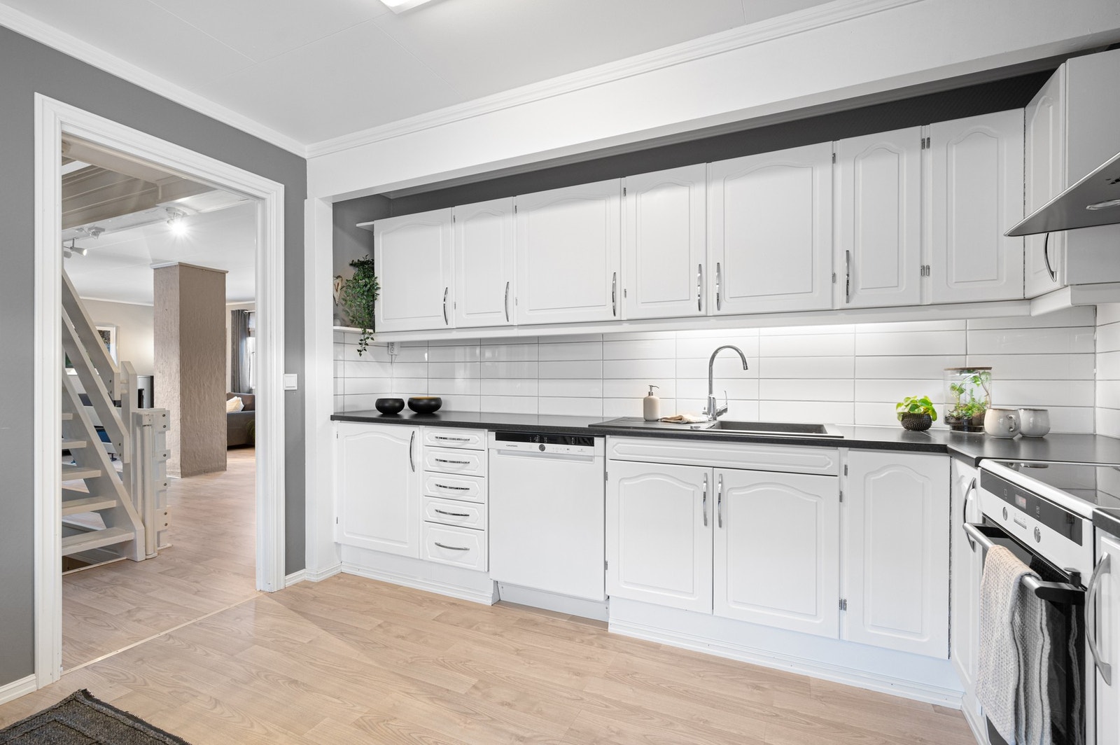 Kjøkkeninnredning i hvitt og sort med stor benkeplass og gode oppbevaringsløsninger. Galleribilde