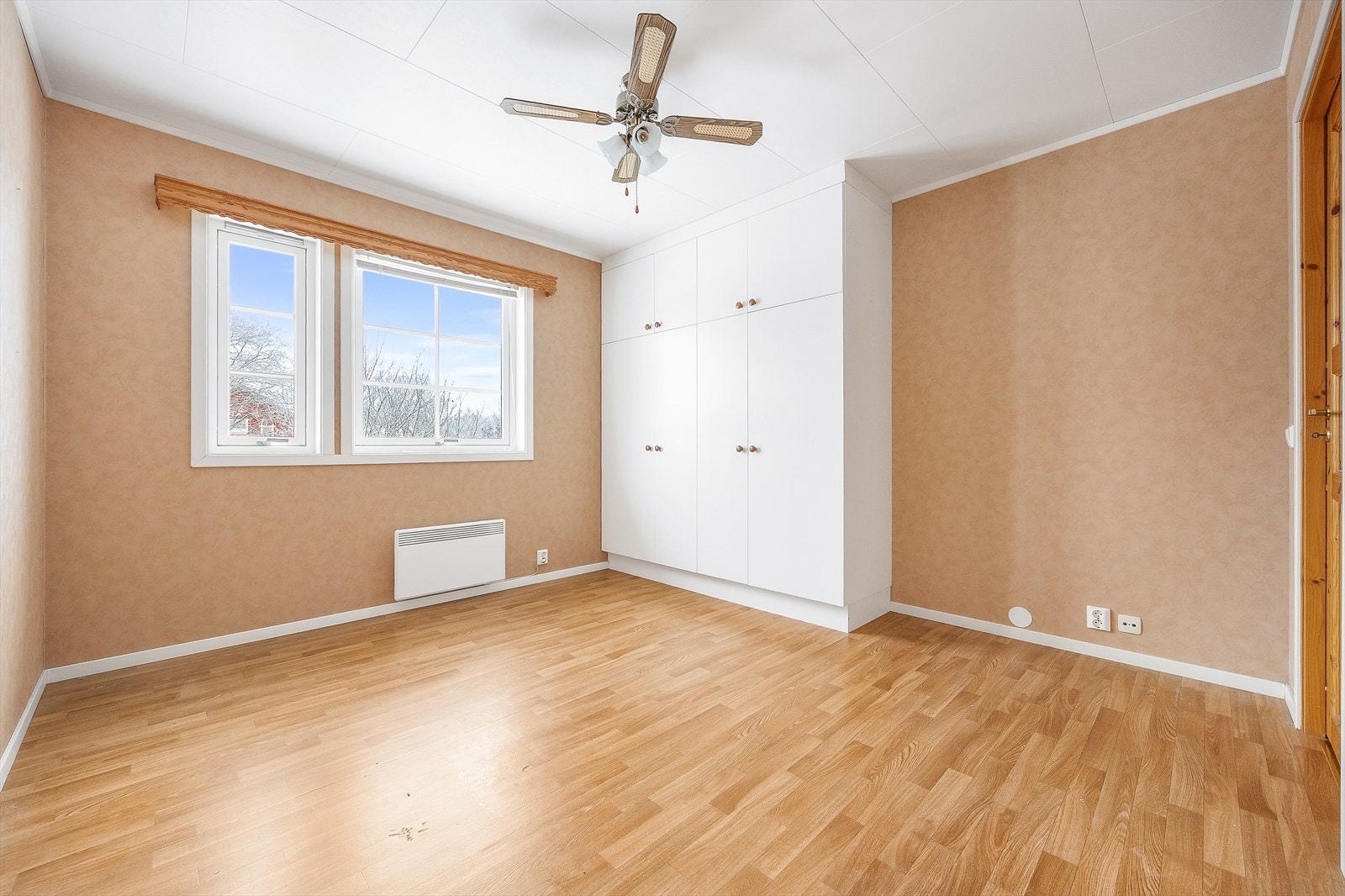 Hovedsoverommet har en ferskenfarget tapet og mulighet for dobbeltseng med tilhørende nattbord. Galleribilde