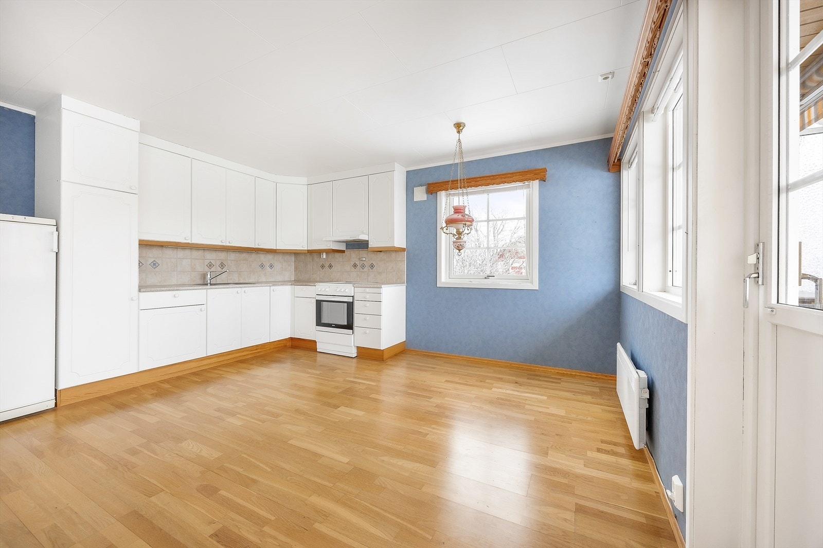 Klassisk kjøkken i L-form med åpen løsning mot stuen. Galleribilde