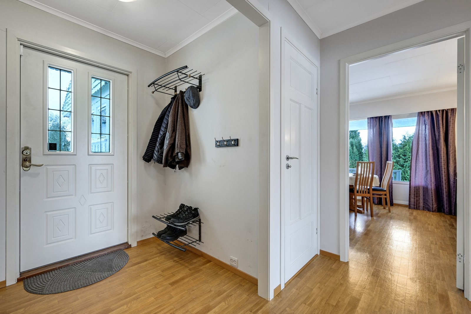 Entre med garderobeplass - døren til høyre er til kjelleren og vi ser litt av stua til høyre Galleribilde