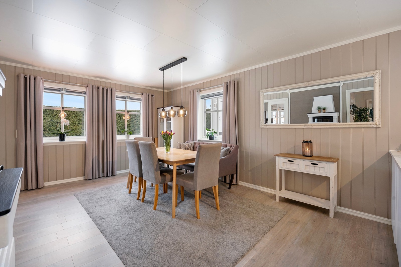 På kjøkkenet er det valgt varmere veggtoner som skaper en lun og stemningsfull atmosfære, samtidig som det er god plass til et romslig spisebord Galleribilde