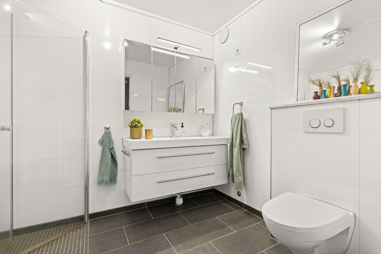 Bad/wc med moderne innredning, dusjvegger, vegghengt wc og varme i gulv Galleribilde